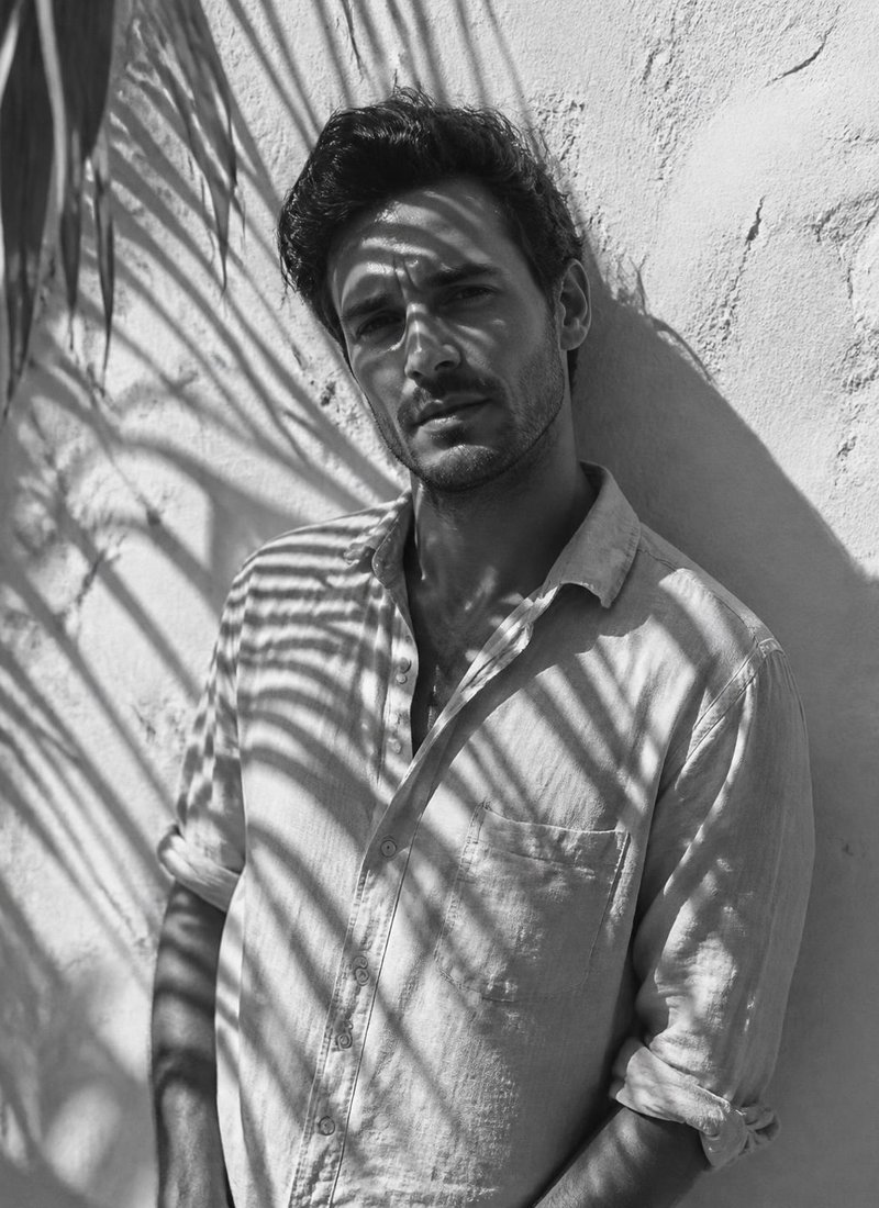 Black-and-white portrait, palm shadows on a wall