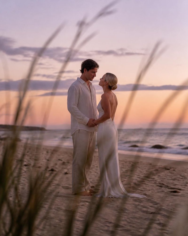 Barefoot vows on the sand at dusk
